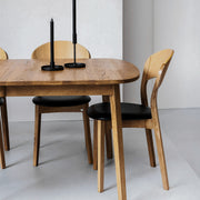 Oak dining table and oak dining chairs with black leather seat at EDITO Furniture